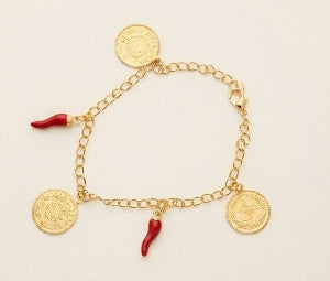 A gold chain bracelet with three gold coin charms and two small red chili pepper charms, displayed on a light cream background.